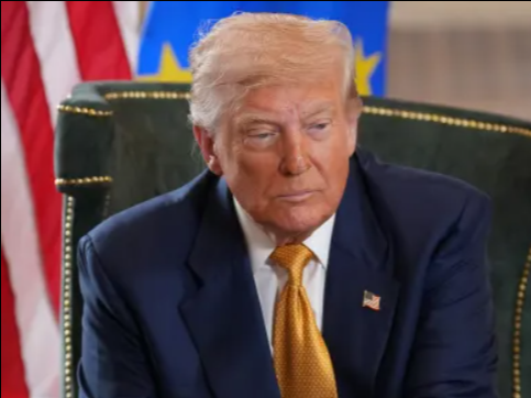 Donald Trump at a meeting with US and EU flags